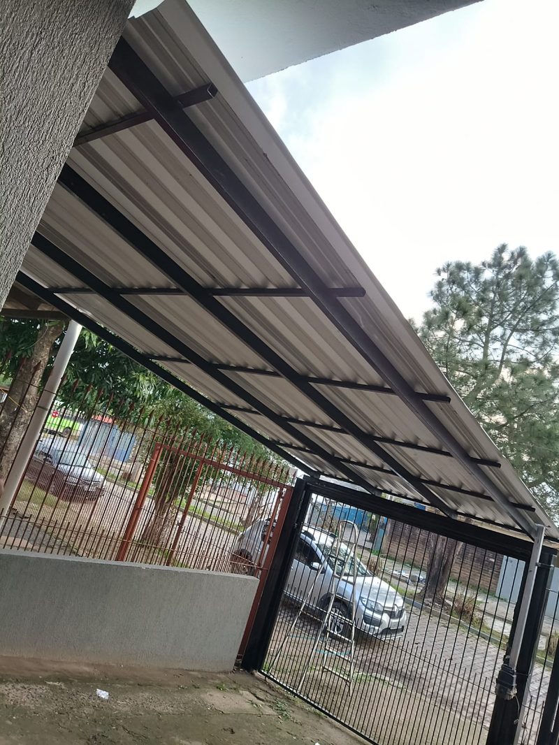 Cobertura metálica sobre grade de entrada de garagem