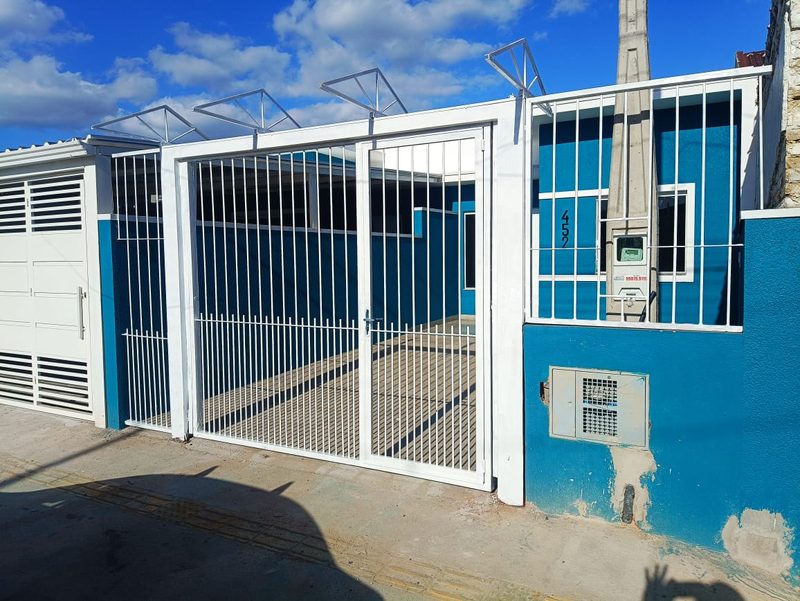 Portão de abrir duplo de ferro pintado de branco, com grade lateral